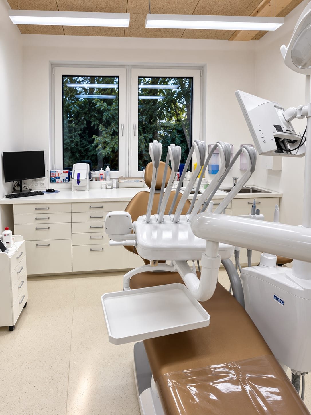 Behandlungsraum der Ordination Payerbach mit Behandlungseinheit, Monitor und Fenster